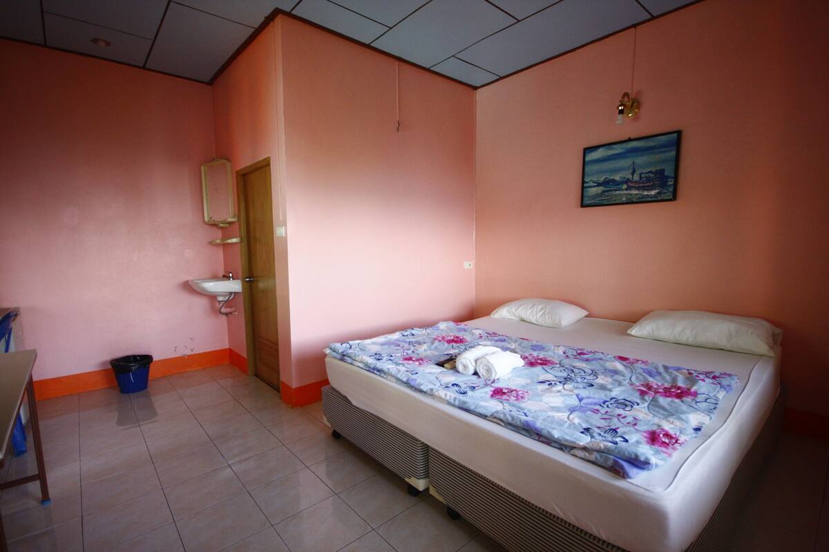 Un dormitorio con cama, lavamanos y puerta.