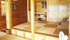 A wooden interior with a checkered floor, a fan, and a clock. - Churahashi (Nakijin)