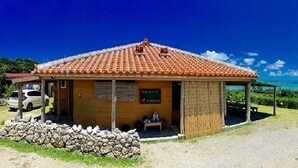 A small building with a tiled roof, a covered porch, and a sign indicating a restaurant. - Churahashi (Nakijin)