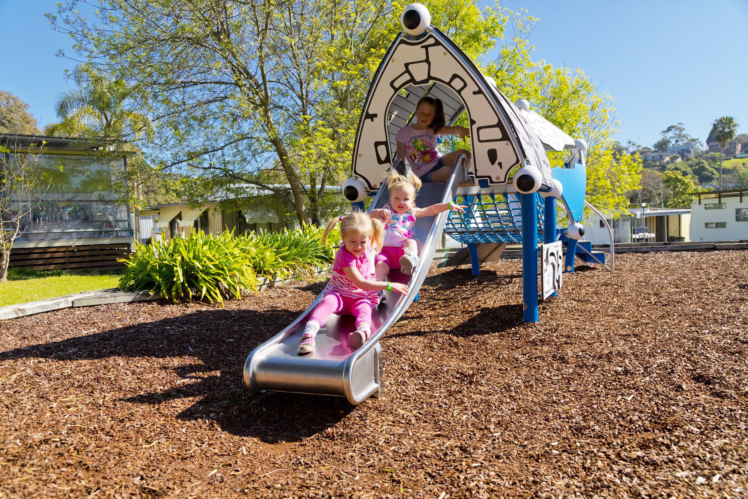 A playground with a slide and climbing structures.