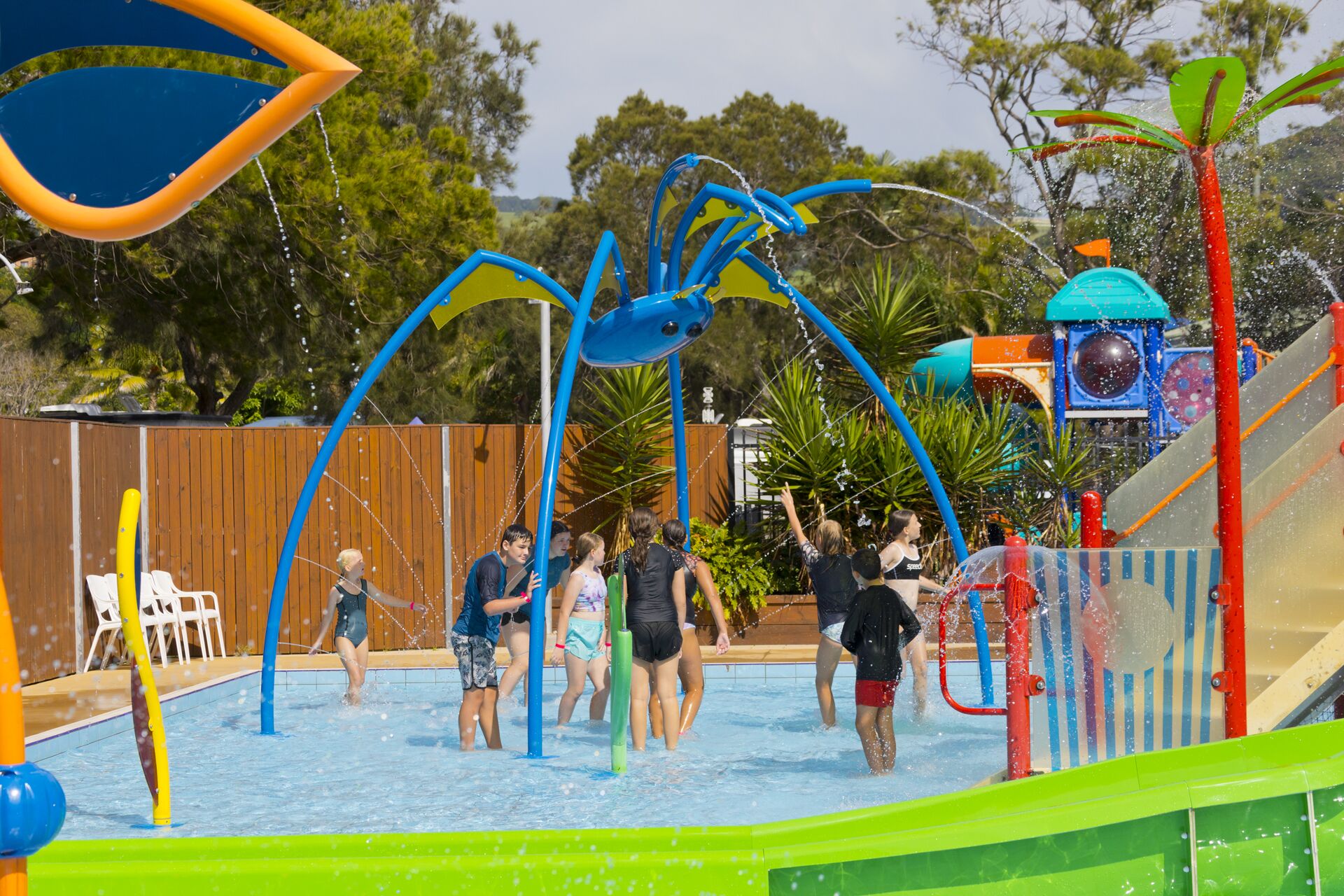 Un parque acuático con un tobogán de agua azul grande y diversas estructuras de juego.