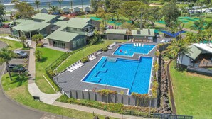 Um resort com duas piscinas, estacionamento e vista para o oceano.