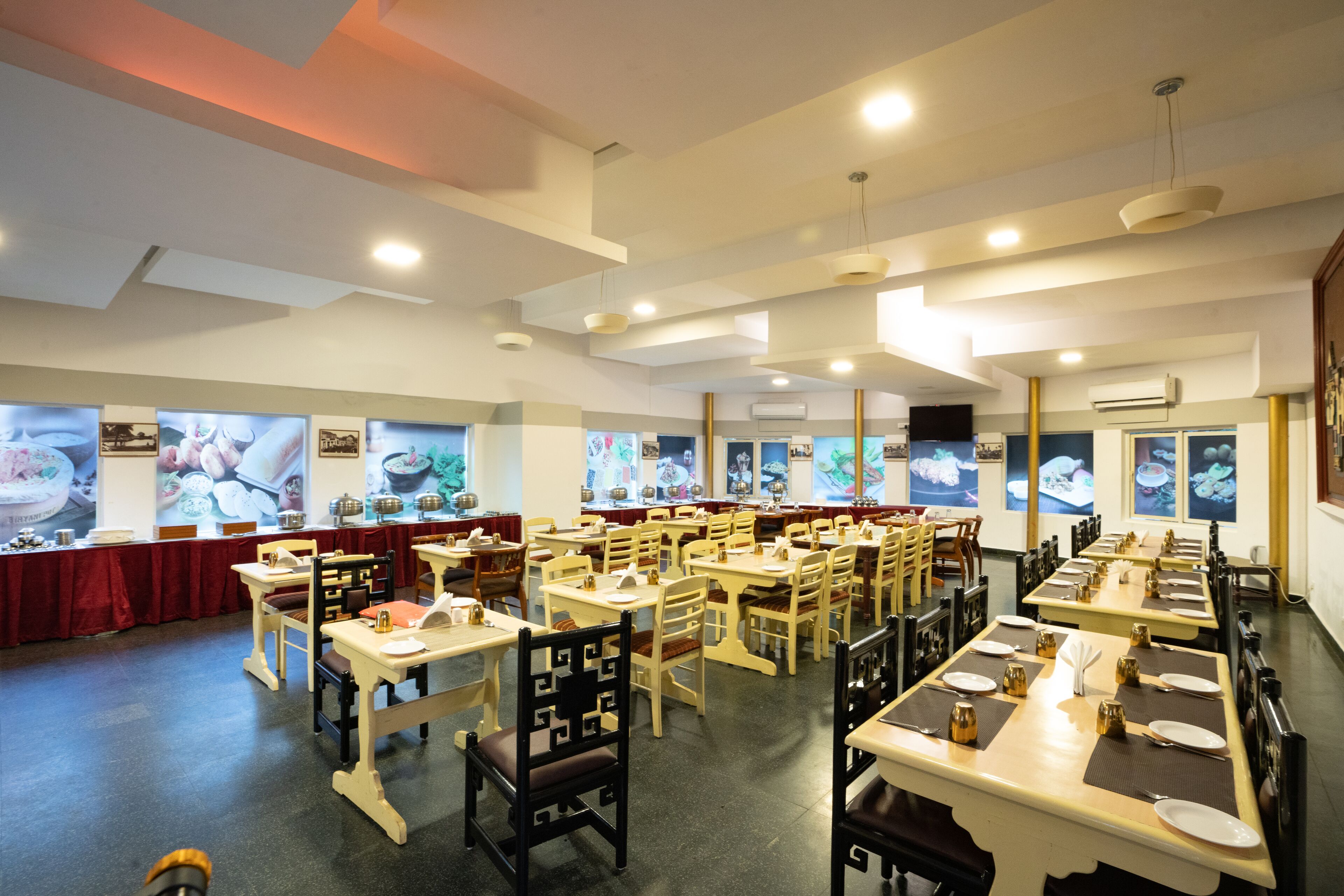A restaurant with multiple dining tables and chairs, arranged in rows.