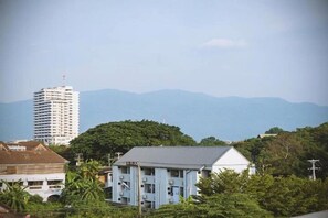 A residential area with a prominent white building, a blue house, and a tall white building in the background.