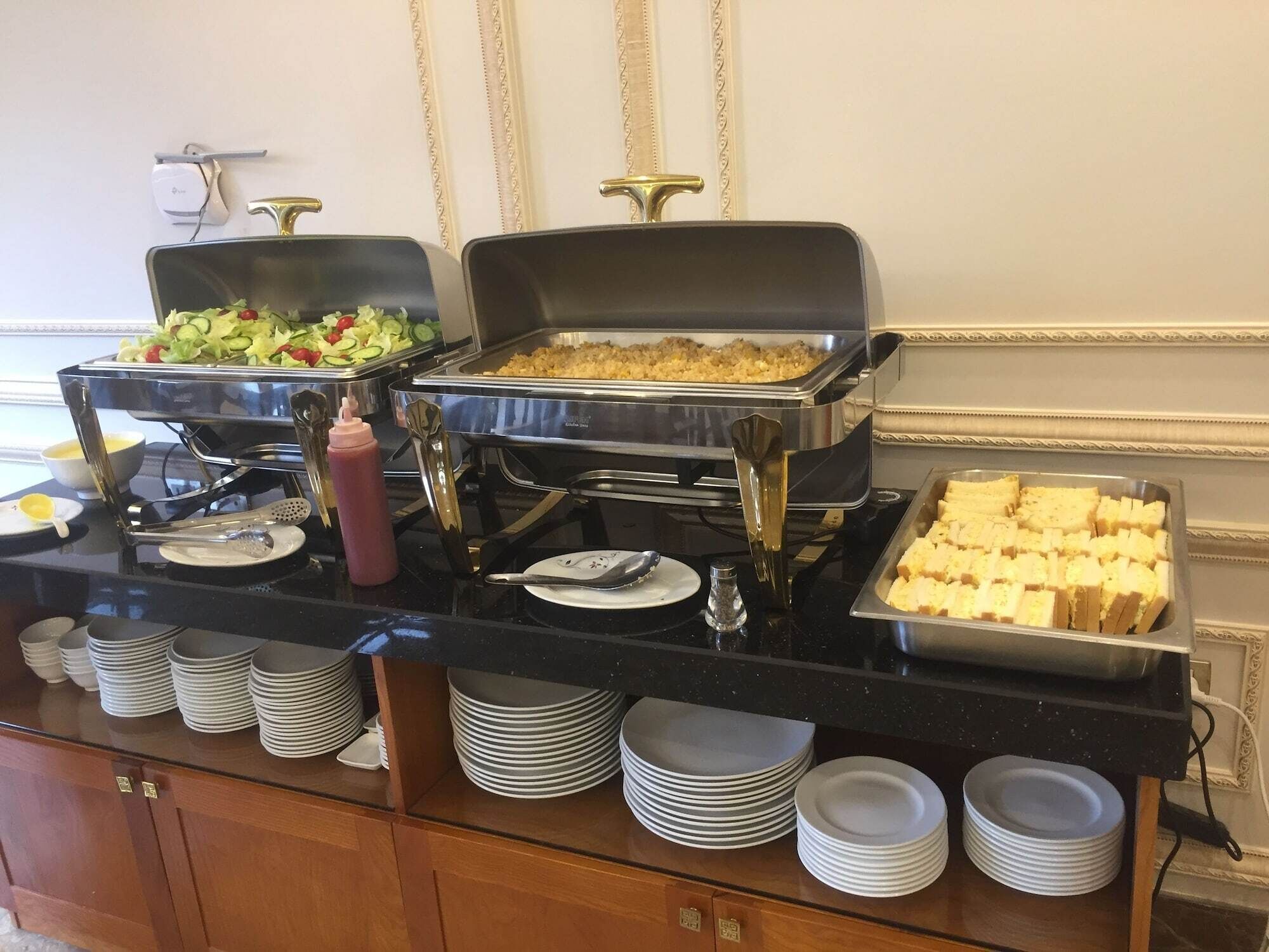 Una mesa de buffet con diferentes alimentos, como ensaladas, cazuelas y pan.