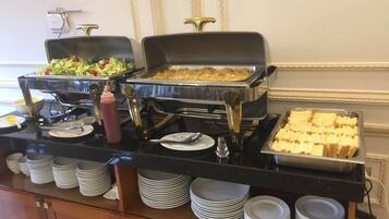 Una mesa de buffet con diferentes alimentos, como ensaladas, cazuelas y pan.