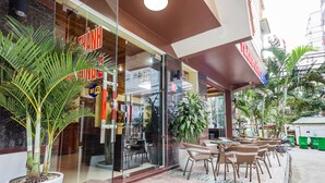 Un restaurante con terraza, una planta grande en maceta y señal de Wi-Fi.