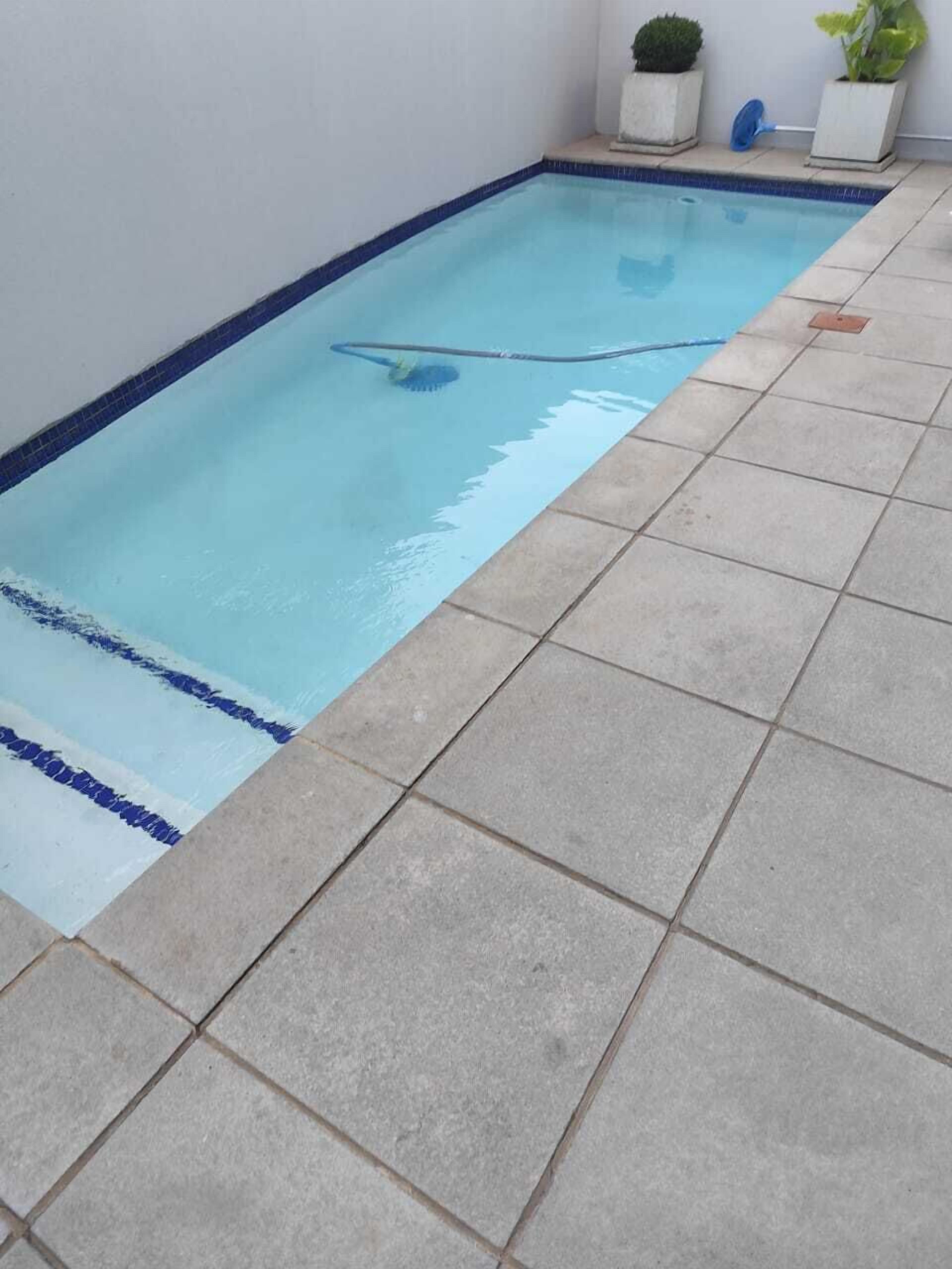 A rectangular swimming pool with a tiled edge and a blue border.
