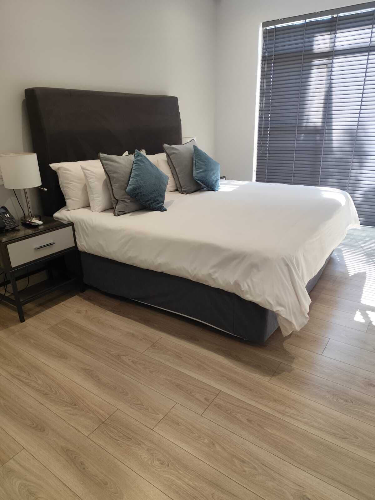 Een moderne slaapkamer met een groot bed, een nachtkastje en een bijpassende salontafel.