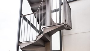 Una escalera en espiral con barandillas metálicas, que conduce a un piso superior.