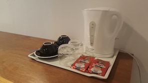 A coffee maker, two cups, two glasses, and two packets of coffee mix on a tray. - Moustachz Hauze (George Town)