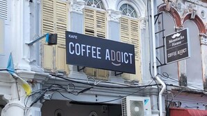 Un bâtiment avec une enseigne indiquant « Coffee Addict » et une autre indiquant « Moustachz Haus ».