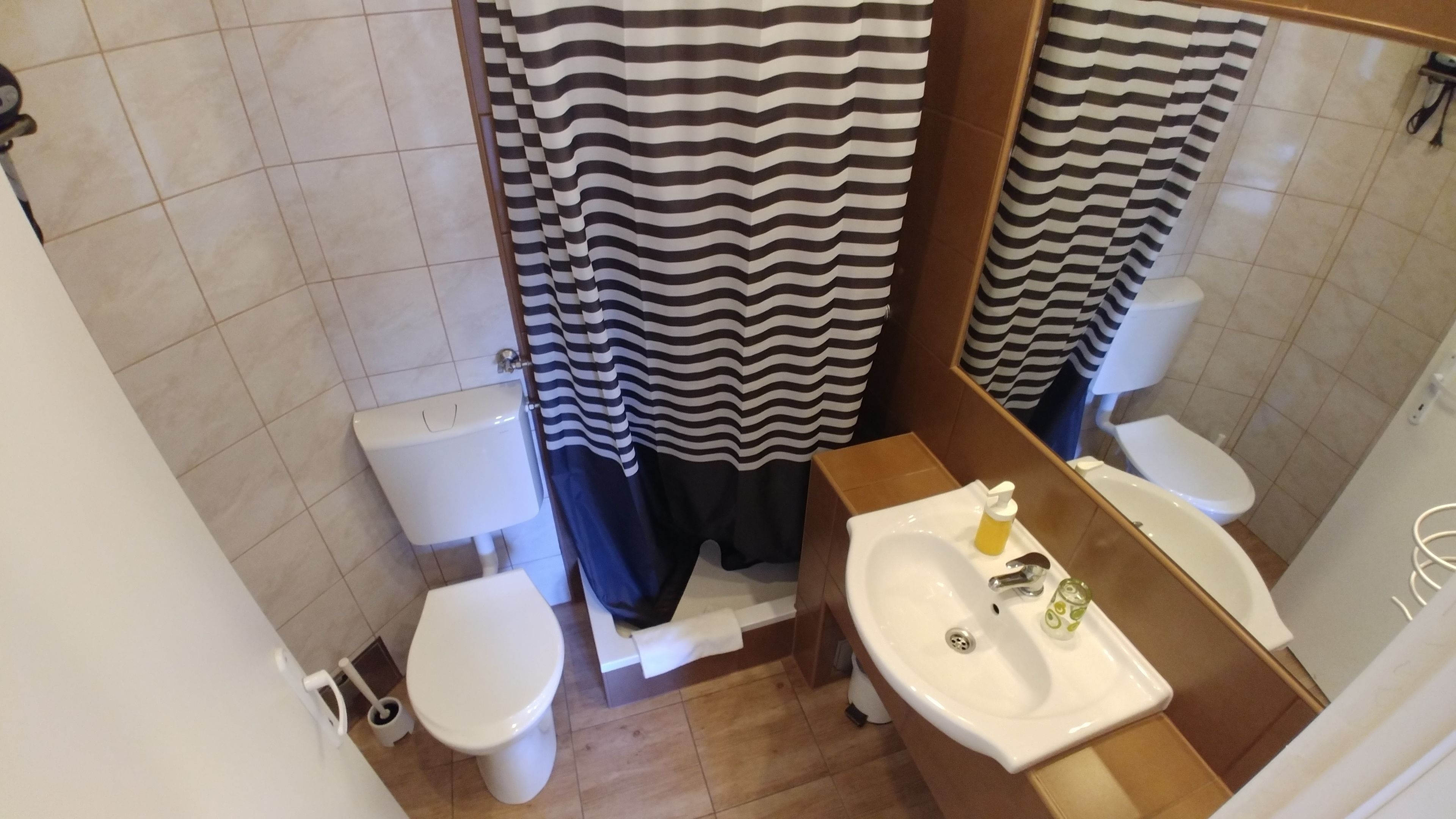 Een badkamer met toilet, hygiëneschuimer en wastafel.