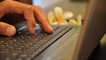 A close-up of a hand typing on a laptop keyboard.