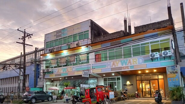 A multi-story building with a sign reading "Hayward Inn." - Hayward Travel Inn (Tacloban)