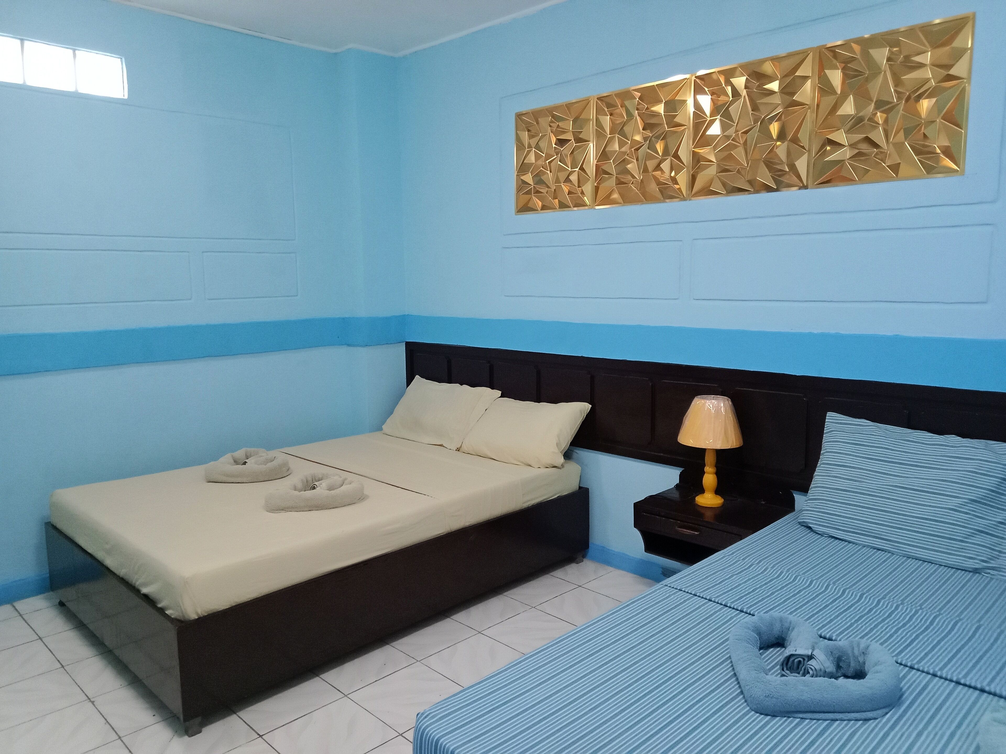 Ein Zimmer mit einem Bett, einem Nachttisch und einer Wanddekoration.