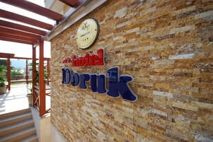 A hotel sign with the name "Doruk" on a textured wall.