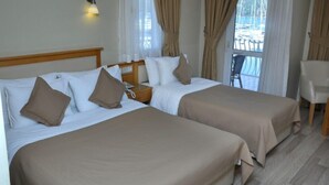 Ein Hotelzimmer mit zwei Betten, einem Holzkopfteil, einem Nachttisch mit Telefon und einem Sessel.