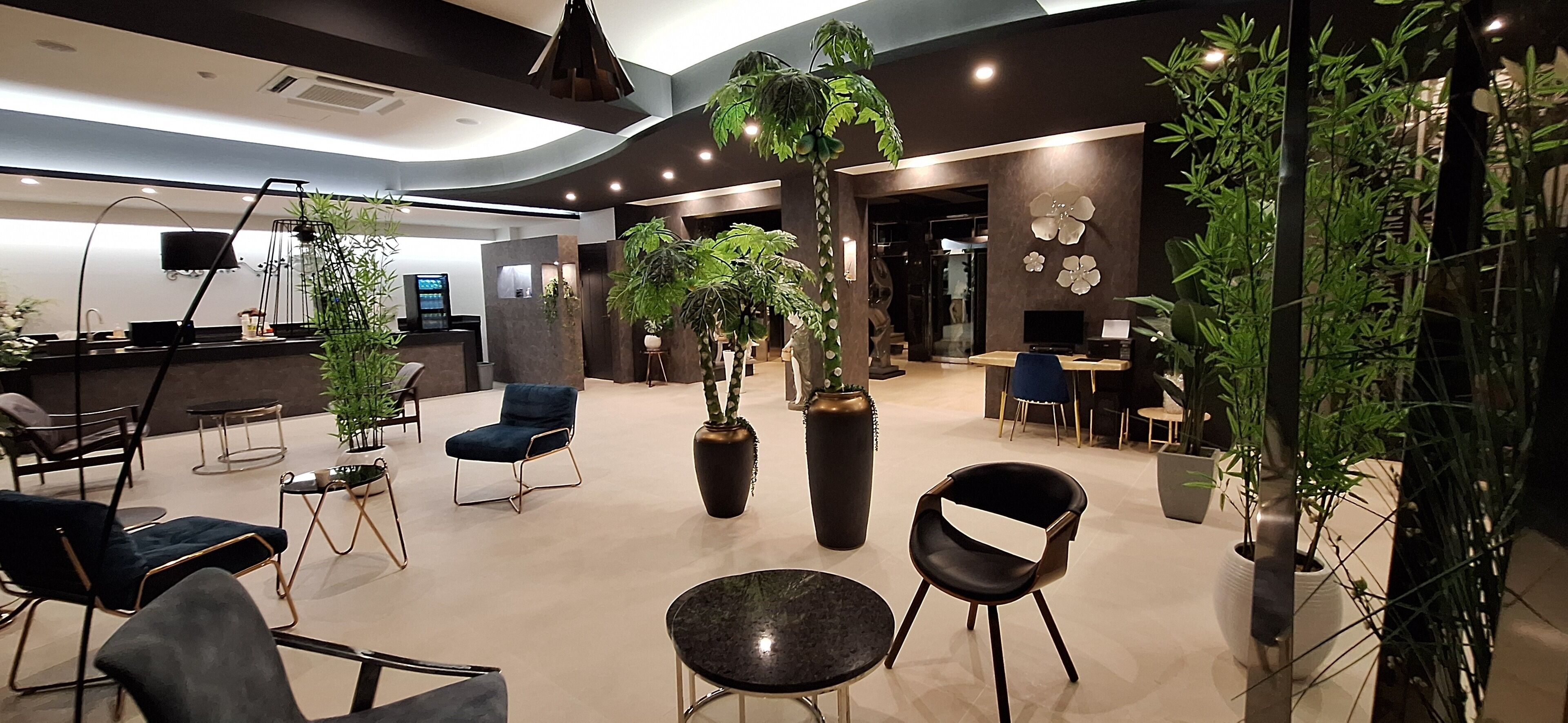 A modern interior with seating, plants, and a reception area.