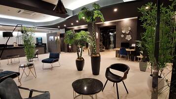 A modern interior with seating, plants, and a reception area.
