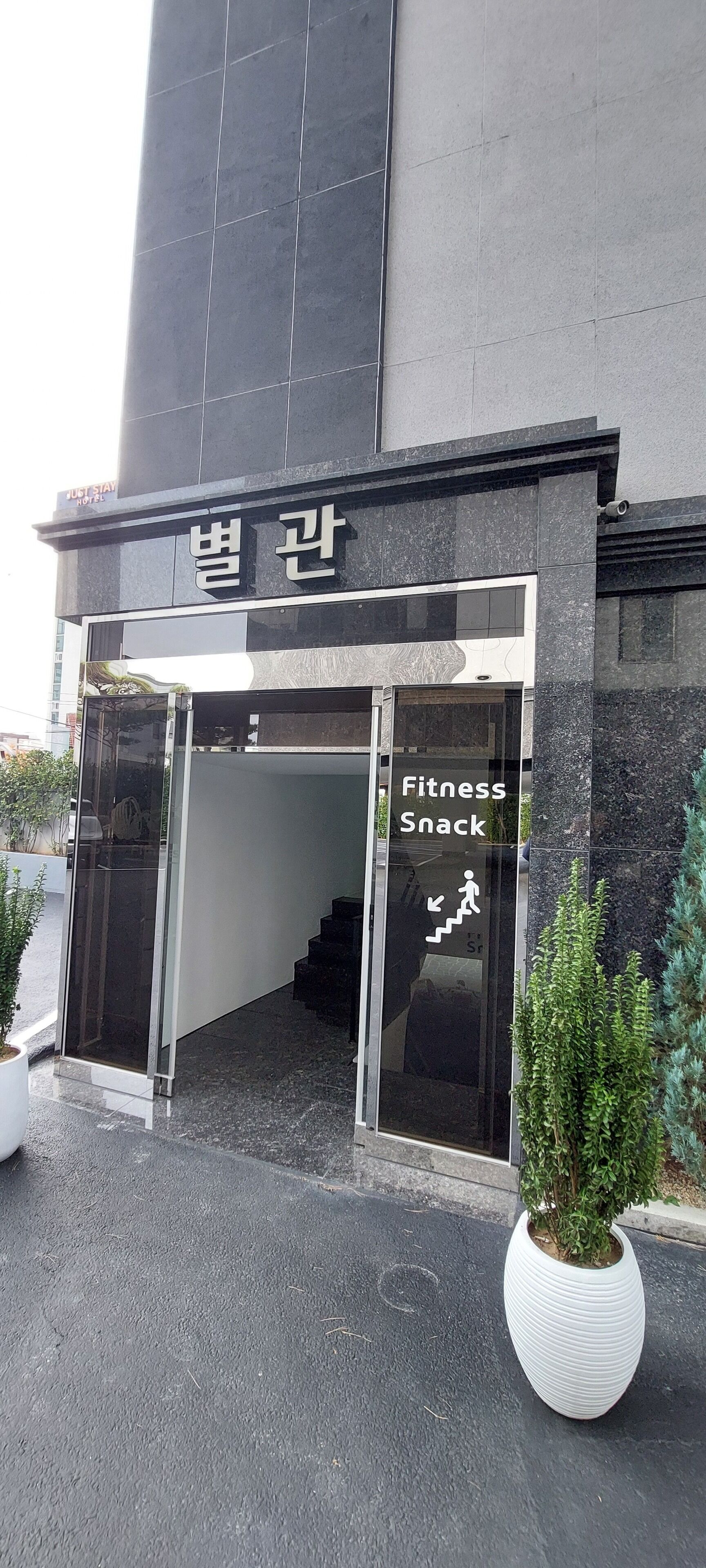 A building entrance with a sign reading "Fitness Snack" and a staircase leading inside.