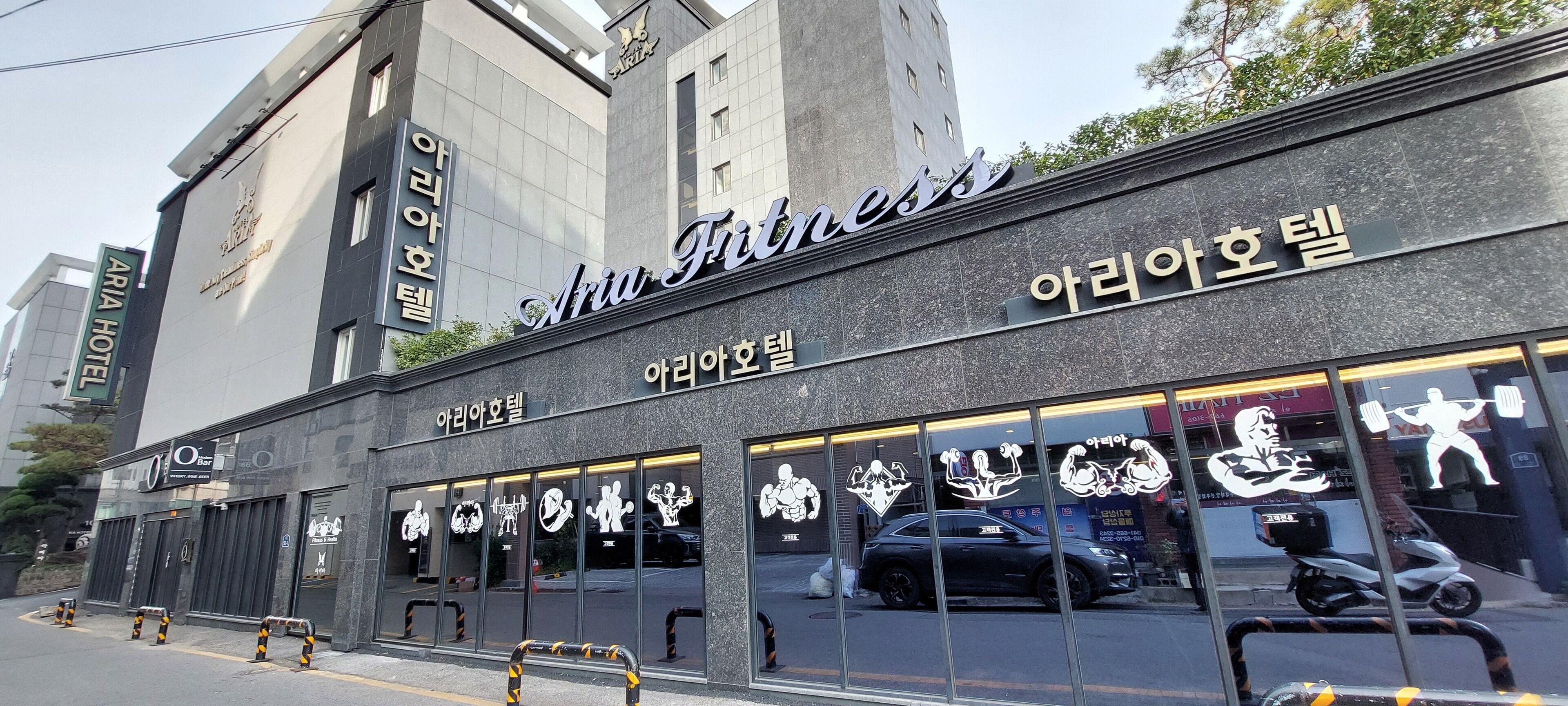 A building with a sign reading "Aria Fitness" and "Aria Hotel".