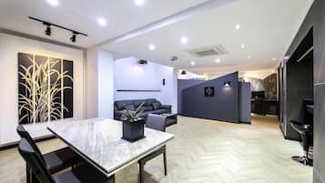 Um interior moderno com área de refeições, um sofá e cozinha.
