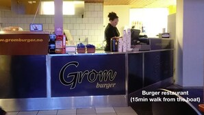 Een hamburgerrestaurant met een menubord boven de toonbank en een bord dat aangeeft dat het 15 minuten reizen is vanaf het schip.