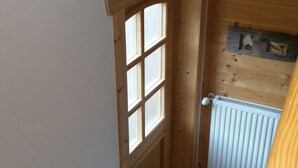 Una escalera de madera que lleva a una habitación con una ventana y un radiador.