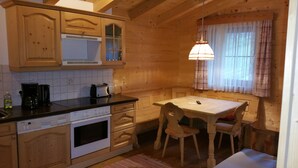 Una cocina de estilo rústico con una mesa y sillas, una cafetera y un tostador.