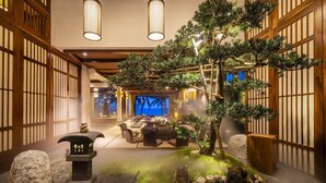 Ein traditionelles japanisches Interieur mit Tatami-Böden, einer zentralen Teezeremonie-Anrichtung und einem ruhigen Steingarten.