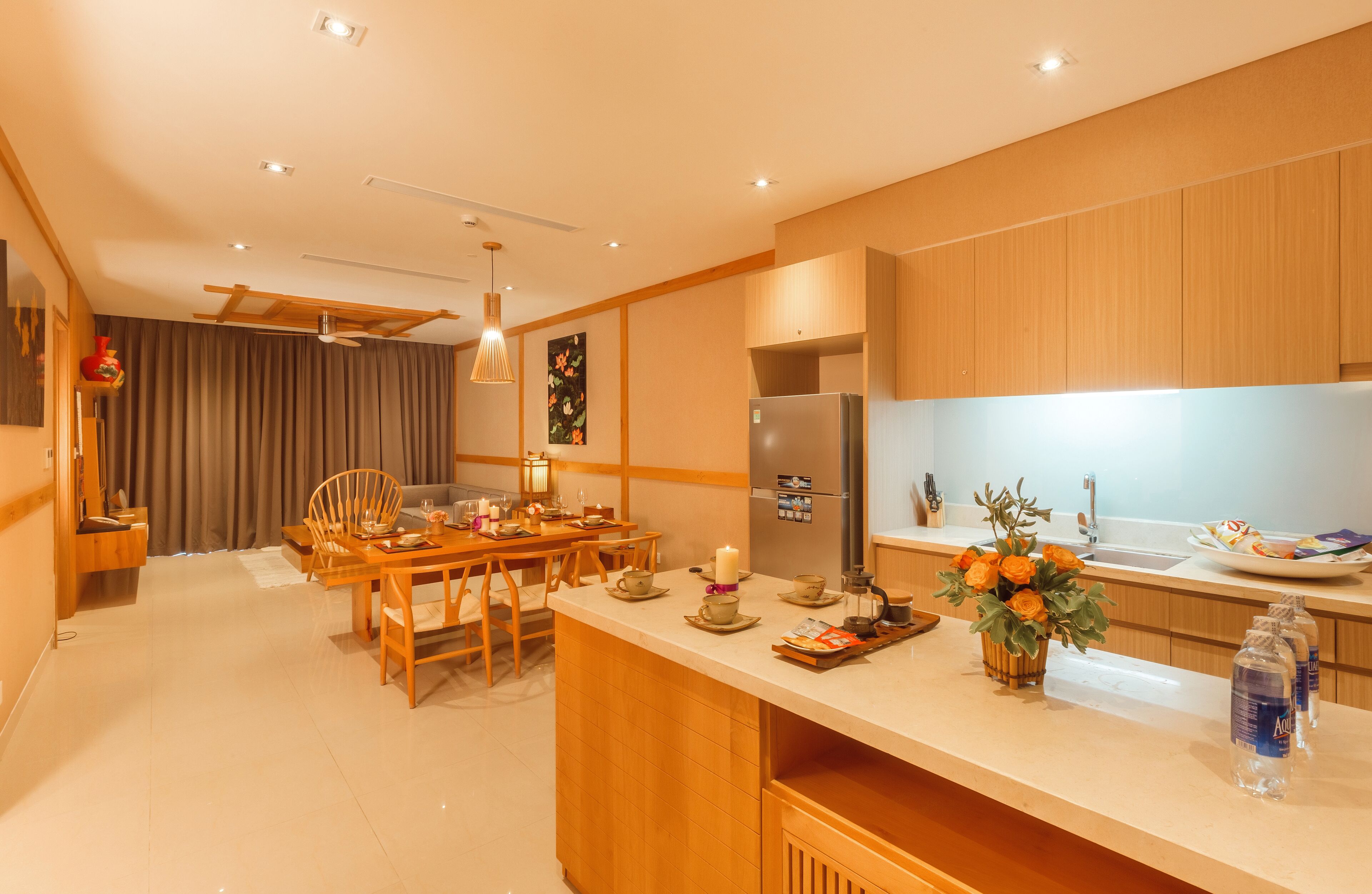 Une cuisine moderne avec des meubles en bois, un îlot central et un coin repas comprenant une table et des chaises.