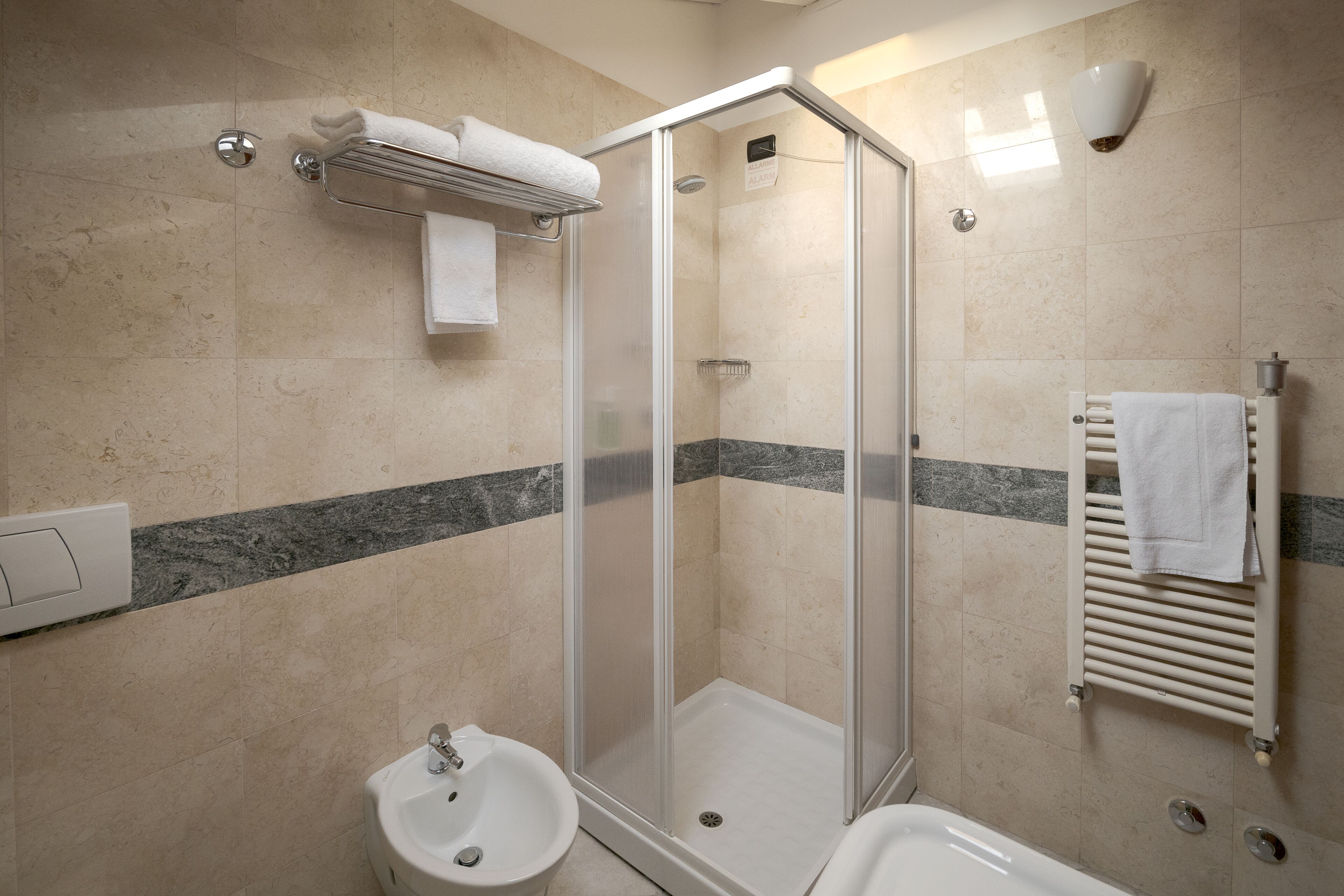 Une salle de bain moderne avec une douche à parois de verre, un lavabo sur colonne et une baignoire.
