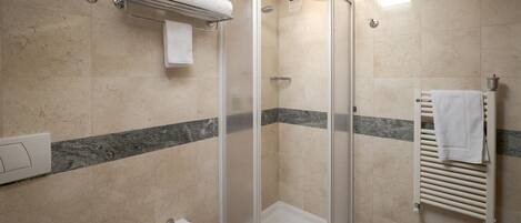 Un baño moderno con ducha de vidrio, lavamanos pedestal y bañera.