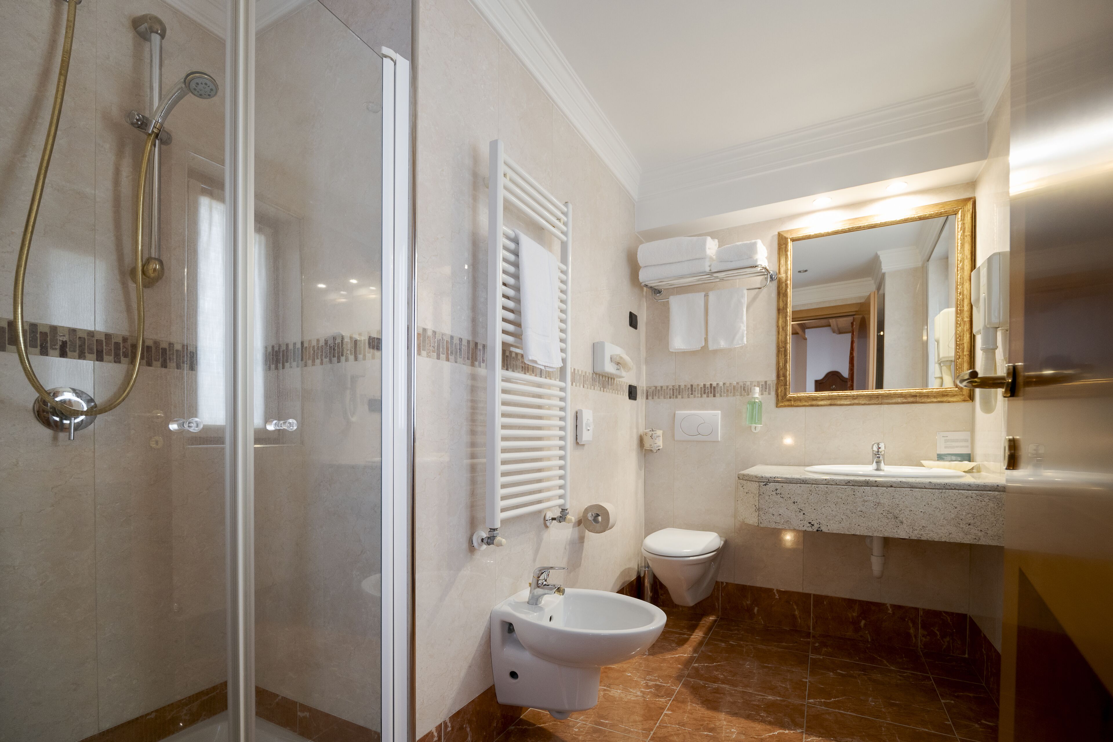 Un baño moderno con ducha de vidrio, lavamanos independiente y un inodoro.