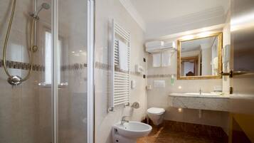 Un baño moderno con ducha de vidrio, lavamanos independiente y un inodoro.