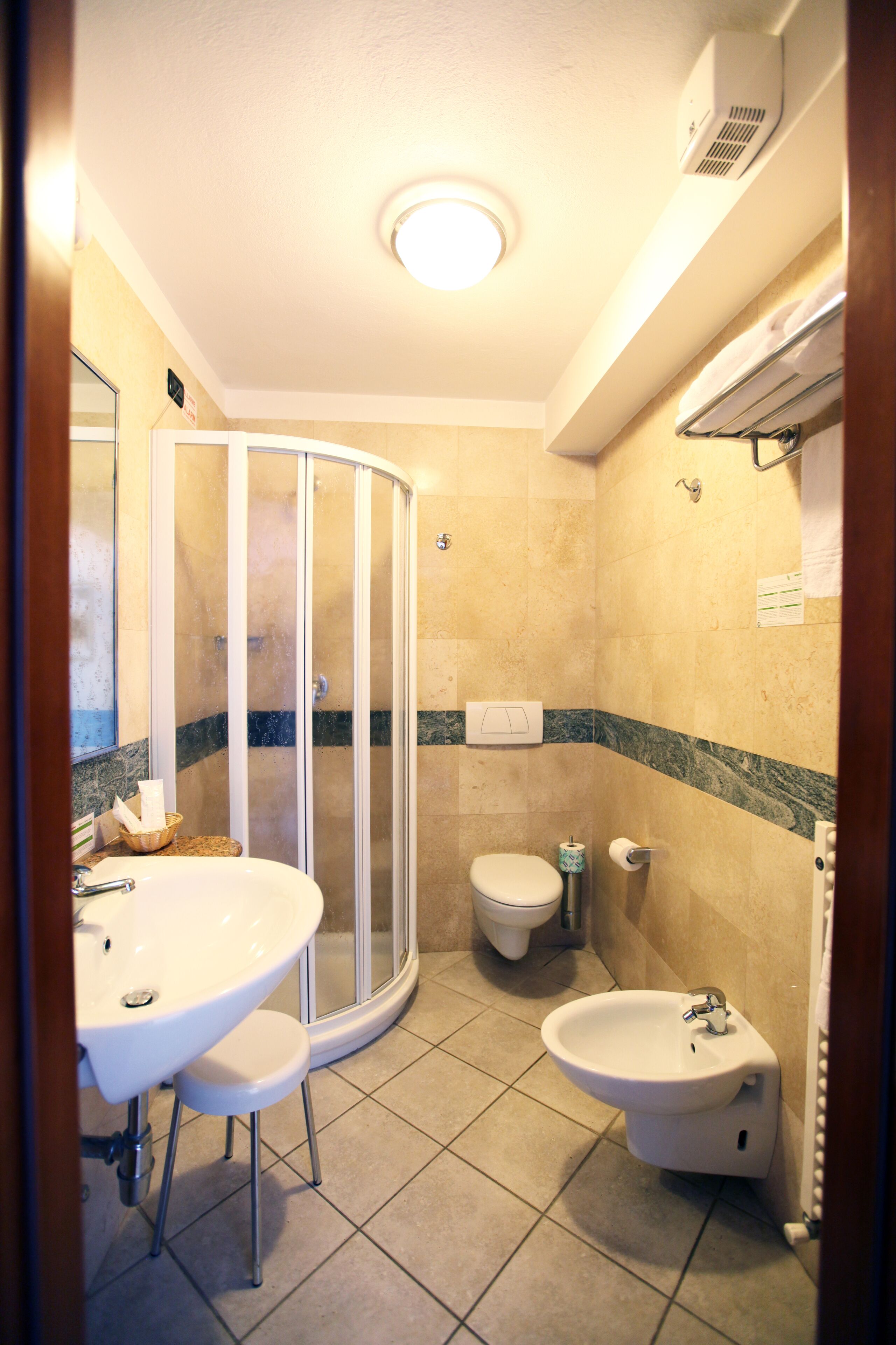 Een badkamer met een douchecabine, toilet, bidet en wastafel.