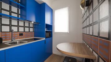A kitchen with blue cabinets, a wooden countertop, and a window.