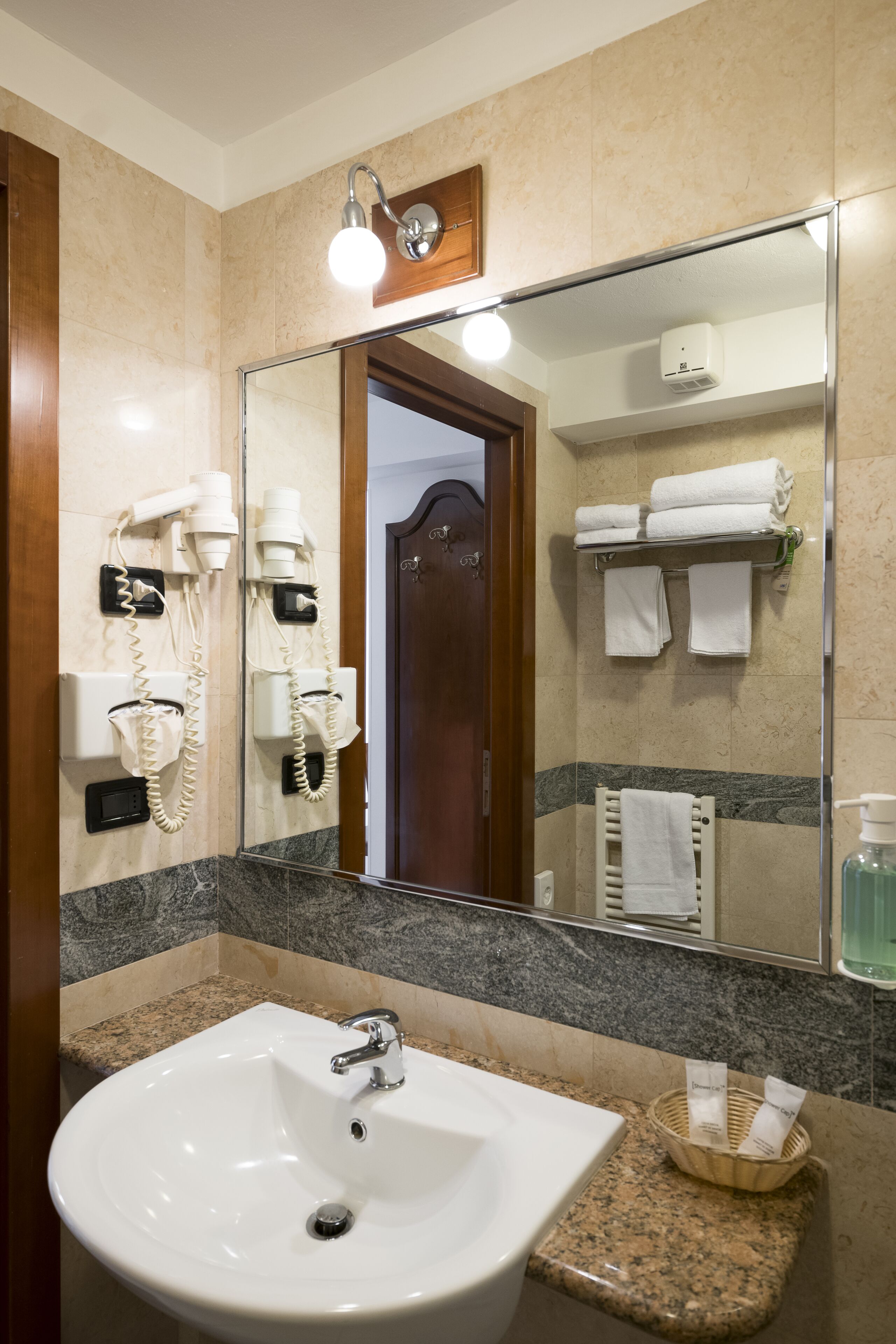 A bathroom with a sink, a hairdryer, and a mirror.