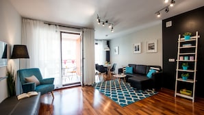 Una sala de estar moderna con un sofá, un sillón y un comedor con sillas y una mesa.