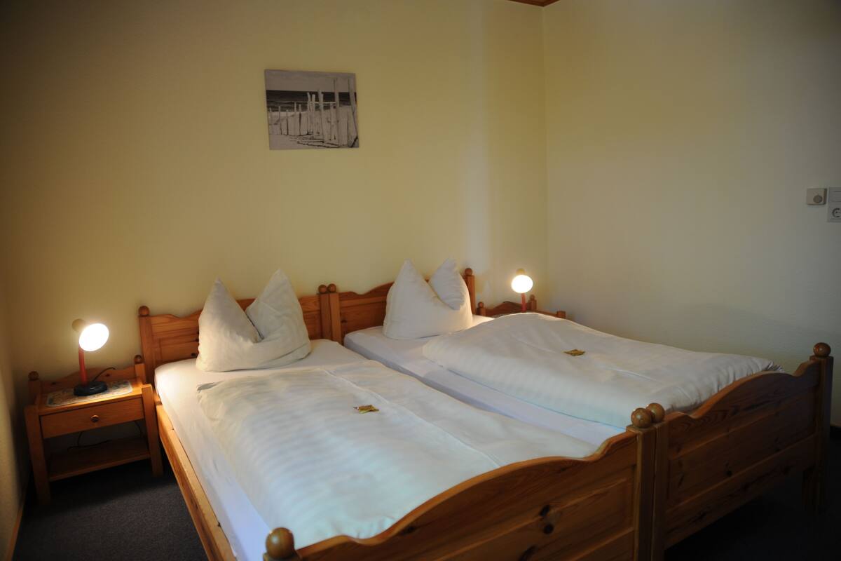 A double bed with two nightstands, each with a lamp.
