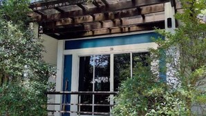 Un petit bâtiment à la façade bleue et blanche, doté d’un toit en bois et d’une fenêtre portant le numéro 09.