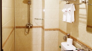 A bathroom with a shower, toilet, sink, and towel rack. - Tiamo Hotel Ha Giang (Ha Giang 2)