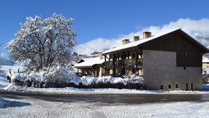 A snow-covered building with a balcony and a clear sky. - Hôtel Restaurant L'Adray (Aime-la-Plagne)