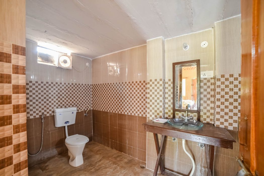Casa de banho com sanita, lavatório e espelho.