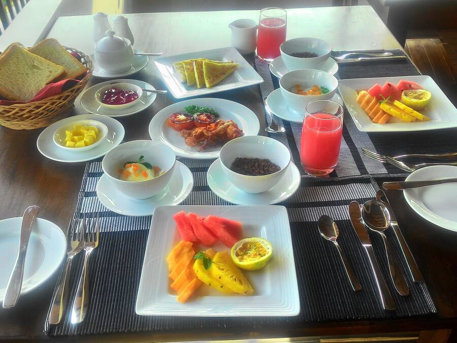 Ein Frühstückstisch mit verschiedenen Speisen, darunter Toast, Obst und Getränke.