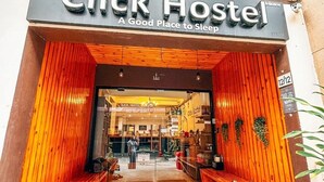 The exterior of Click Hostel with a wooden facade and a sign that reads "Click Hostel: A Good Place to Sleep". - Click Hostel (Bangkok)