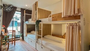 A compact, well-lit room with bunk beds, a small table with chairs, and a window with curtains. - Click Hostel (Bangkok)