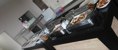 A buffet setup with various food items and condiments.
