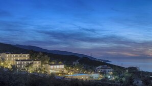 Um imóvel costeiro com vários edifícios, piscina e vista para o mar.